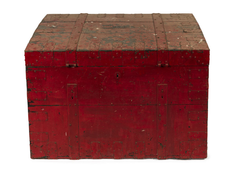 A rustic antique steamer trunk, red painted finish on timber with brass bindings and heavy twin iron handles to each end, 19th century, 61cm high, 92cm wide, 63cm deep