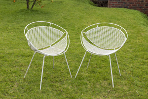 A pair of vintage cone shaped iron garden chairs with white painted finish, mid 20th century, 64cm across the arms