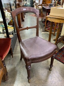 An antique English carved walnut side chair with unusual brass castors, late 19th century