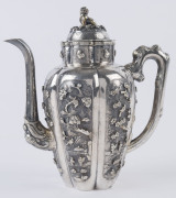 An antique Chinese silver teapot adorned with vignettes of country scenes and floral sprays, Foo dog finial with remains of gilt highlights, 19th century, 18cm high, 17cm wide, 565grams - 2