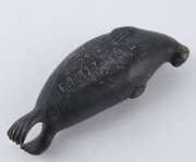 A Canadian Inuit greenstone carving in the form of a walrus, signed and numbered to the base, 20th century, 12cm long - 3