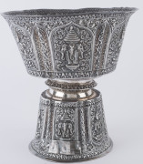 A Laotian silver footed bowl with repousse decorated and alternating panels of the three-headed elephant (airavata) and deities, separated by elaborate floral scrolling and borders with foliate lotus leaf pattern, early 20th century. A silver plaque attac - 4