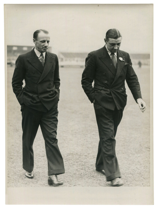 DON BRADMAN - ENGLAND vs AUSTRALIA, 4th TEST, OLD TRAFFORD, JULY 22-26, 1938: original press photograph (Fox Photos, London), showing a besuited Bradman & Wally Hammond walking back to the pavilion after having inspected the wicket; 14.5 x 19.5cm. Austra