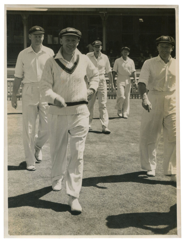 DON BRADMAN - AUSTRALIA vs INDIA 1947-48 Test Series: original press photograph ("The Sun" Feature Bureau), showing Bradman leading out Australian players during the series; 15.5 x 21cm.