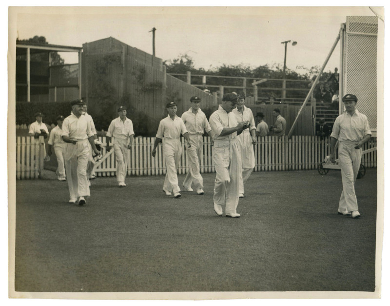 DON BRADMAN - AUSTRALIA vs INDIA, 1st TEST, BRISBANE, Nov.28 - Dec.2, 1947: original press photograph ("The Telegraph", Brisbane), showing Australian captain Don Bradman leading his team out onto the ground; 21 x 16.5cm.