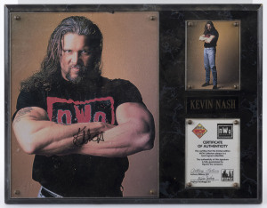 WRESTLING - KEVIN NASH - WCW HEAVYWEIGHT CHAMPION: mounted display featuring SIGNED PHOTOGRAPH (28x21cm) of a young Nash plus smaller image of Nash (10x8cm) and a mounted Figures Toy Co CofA; all items within the display are perspex protected, overall 30x38cm. Kevin Nash was five-times WCW World Heavyweight Champion and one-time WWF Heavyweight Champion. He was the first wrestler to defeat "Goldberg" (Bill Goldberg), ending his undefeated run of 173-0, at the "Starrcade" event in 1998.