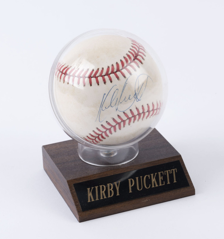 BASEBALL - KIRBY PUCKETT: signed baseball on small faux wood presentation stand, "Official Licensee/Major League Baseball" and "All Stars" (retailers) labels on base.