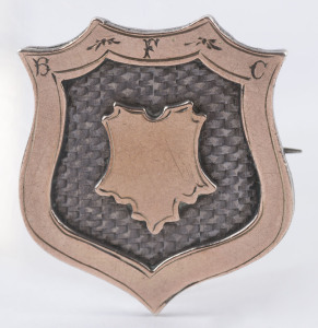 BEAUFORT FOOTBALL CLUB: 9ct gold and sterling silver shield-shaped badge engraved "B.F.C." to front, and verso "PRESENTED TO T.W.SCHLICHT by H.J. RICHARDS - BEST ALL ROUND PLAYER - B.F.C. 1908."