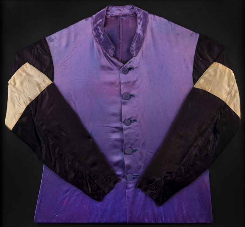 THE 1954 MELBOURNE CUP WINNER - RISING FAST: Jockey Silks believed to have been worn by Jack Purtell during the 1954 Melbourne Cup, purple body, black sleeves with pale gold bands, archivally framed, overall 86x83cm. Accompanied by a framed original press