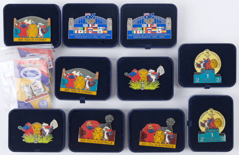 SYDNEY 2000: Olympic Games Mascot Pins x5 different designs, each design with a single duplicate, all in original plush-lined presentation boxes; also two '17 Months To Go' pins in original packaging. (12)