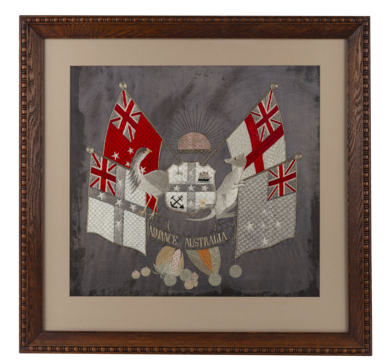 A fine and rare silk and silver thread embroidered Australian coat-of-arms, circa 1890s, the central shield depicting cattle, shipping, mining and wheat harvesting, supported by an inward facing emu (left) and kangaroo (right), surrounded by four flags,