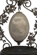 An Australian silver plated emu egg ornament, foliate design with cast emu finial and suspended emu egg carved and decorated with cockatoo and emu in landscape, mounted on ebonised timber plinth, late 19th century, 29cm high. PROVENANCE: Christie's Aucti - 2