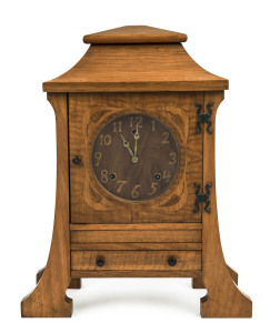 ROBERT PRENZEL (attributed), rare Australian Art Nouveau mantel clock, early 20th century. Shallow stepped inverted bell top case supported on full height sabre pilasters terminating in out swept feet, marquetry inlaid black bean dial with maple inlaid Arabic numerals and brass spade hands, fiddleback maple hinged door with leaf floral inlay to the corners and decorative patinated copper strap hinges. Case unusually fitted with a single drawer for clock key storage with figured blackwood knobs,