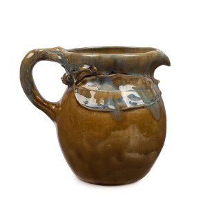 PHILIPPA JAMES brown and blue glazed pottery jug with applied gum leaf and blossoms, incised "Philippa James" ​16cm high