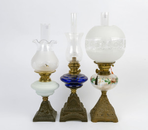 Three kerosene lamps with floral cast iron bases, each with glass fonts, late 19th century, (3 items), the largest 55cm high