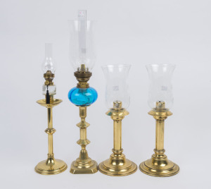 Four brass candlestick lamps, comprising of a pair with spring loaded candle feeders with etched glass shades, the other two later converted into kerosene lamps with glass fonts, single brass burners and glass chimneys, early 20th century, (4 items), the 