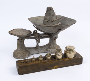 A pair of gilt painted cast iron countertop shop weighing scales with seven graduated weights, along with a graduated set of brass cylinder form weights on wooden stand, early 20th century, 15 items, the scales 20.5cm high, 37cm wide, 30cm deep