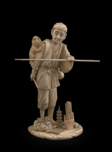 A Japanese carved ivory statue man with monkey, Meiji period, 19th century, 21.5cm high