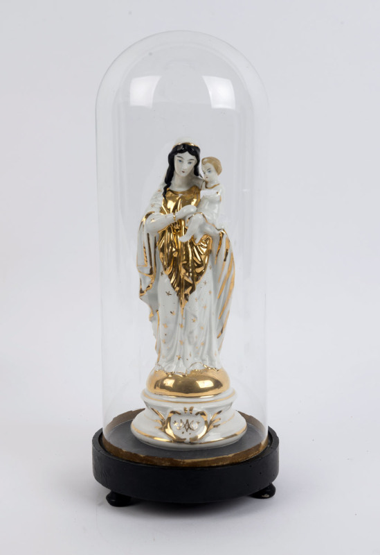 A cylindrical French glass dome containing a Virgin Mary and baby Jesus porcelain figure with gilt decoration and impressed factory mark to the base, on an ebonised plinth resting on three bun feet. 19th/20th century. Dome measurements 36cm high, 15cm wid