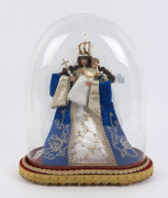 A large oval French glass dome containing a Virgin Mary and baby Jesus wax figure in embroidered costume on a red velour and gold braided timber base with four bun feet, late 19th/20th century. Dome measurements 36.5cm high, 29cm wide.