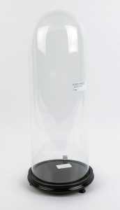 A tall cylindrical French glass dome on ebonised ogee moulded timber base with three bun feet, 19th century. the dome 57cm high, 21cm diameter.