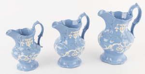 A graduated set of three slip ware English porcelain jugs, 19th century, the largest 21cm high