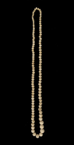 An antique carved whalebone graduated bead necklace, 19th century, ​71cm long