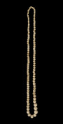 An antique carved whalebone graduated bead necklace, 19th century, ​71cm long