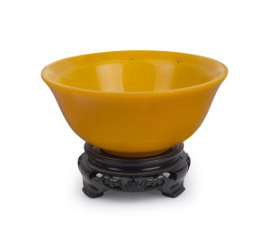 PEIKING GLASS bowl in Imperial yellow on carved wooden stand, 19th/20th century, 6.5cm high, 14.4cm diameter