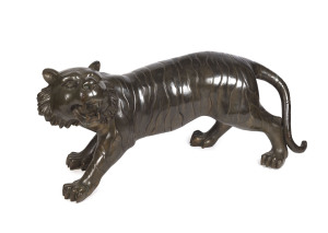 A Chinese bronze tiger statue, 20th century, 58cm high, 135cm long