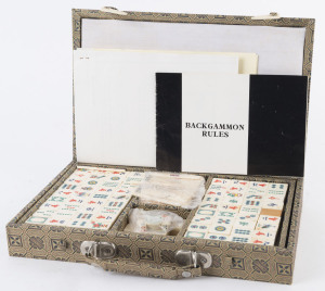 A Chinese vintage Mah-Jong set with bone and bamboo tiles in a silk covered case, mid 20th century, the case 31cm wide