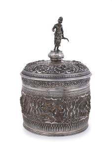A stunning antique Burmese silver ceremonial betel box. Decorated with six deep repoussé cartouches showing Burmese mythological scenes with lotus and scroll frieze. The lid also beautifully worked in repoussé with seven further figural vignettes and a sp