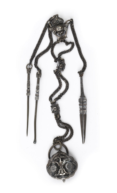 An antique Chinese silver gentleman's chatelaine grooming set, Qing Dynasty, 19th century. Comprising of an earpick, nail pick and tweezers hung from a long silver chain adorned with rosettes and a monkey face representing high rank and fertility. 34cm lo