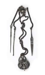 An antique Chinese silver gentleman's chatelaine grooming set, Qing Dynasty, 19th century. Comprising of an earpick, nail pick and tweezers hung from a long silver chain adorned with rosettes and a monkey face representing high rank and fertility. 34cm long