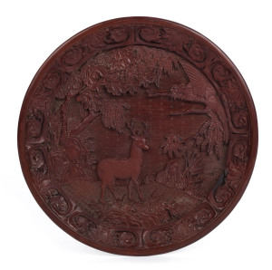 A Chinese carved cinnabar lacquered platter, Qing Dynasty, late 18th century, Qianlong mark rendered in gold, 30cm diameter