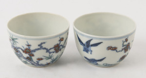 Two Chinese porcelain teacups with Doucai decoration with birds and blossoms in landscape, 19th/20th century, Yongzheng underglaze blue six character mark, 4cm high
