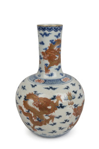 An antique Chinese porcelain vase decorated with five iron red and gold celestial dragons on underglaze blue and white ground, Guangxu period, Qing Dynasty, late 19th century early 20th century, Qianlong underglaze blue six character mark to base, 38cm high. PROVENANCE Private Collection, Toorak, Melbourne.