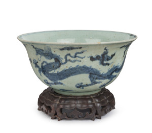 An antique Chinese porcelain bowl with underglaze phoenix decoration, late Ming Dynasty, with later finely carved antique wooden stand, the bowl 12cm high, 25.5cm diameter