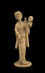 A Japanese carved ivory statue of a lady and child with grapes, Meiji period, 19th century, with two character seal mark to base, ​17cm high