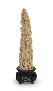 An antique Chinese carved ivory floral ornament on original carved wooden stand, early Republic Period, ​17.5cm high overall