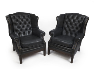 A pair of Georgian style wingback armchairs with black studded leather upholstery, late 20th century, 104cm high, 80cm across the arms