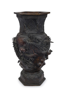 An antique Japanese bronze dragon vase with hexagonal form top, 36cm high