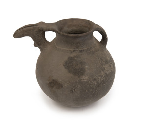 An Amlash burnished black earthenware libation vessel with zoomorphic spout, and single lug handle, West Asian origin, 8th century B.C. 20cm high, 24cm wide. PROVENANCE: Graham Cornell Collection, Mossgreen Auctions, Melbourne.