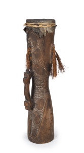 A tribal drum, carved wood, lizard skin and fibre with remains of piped clay and ochre, Huon Gulf, East Papua New Guinea, ​81cm high