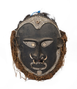An impressive tribal mask, tortoiseshell, feather, tusk, shell, fibre and clay with earth pigments, coastal Papua New Guinea, 120cm high