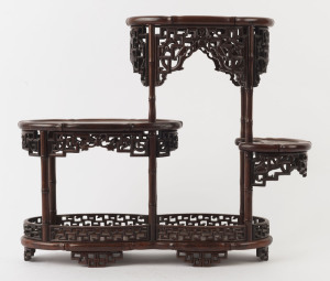 A Chinese four tier display stand, carved rosewood with pierced dragon decoration and faux bamboo, late Qing dynasty, 38cm high