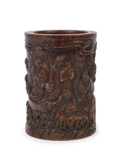 A Chinese carved horn brush pot with scene of Sages in a mountain landscape playing board games, Qing Dynasty 19th century, 12cm high, 9.5cm wide