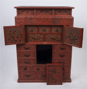 An antique Japanese red lacquered cabinet, profusely decorated on all sides. 18th century. 117cm high, 82cm wide, 34cm wide. PROVENANCE: Purchased from Spink & Son Ltd. London in 1927 for £200. formerly part of the Anderson Collection, England. - 2