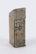 An antique novelty vesta in the form of an outhouse with side door revealing a gentleman in top hat performing his morning ablutions, cast metal with remains of silver plating, 19th century, 5cm high - 2