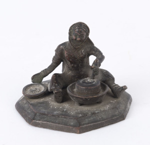 An Indian bronze statue of a seated figure with grinding stone, 19th century, 6cm high, 8cm wide